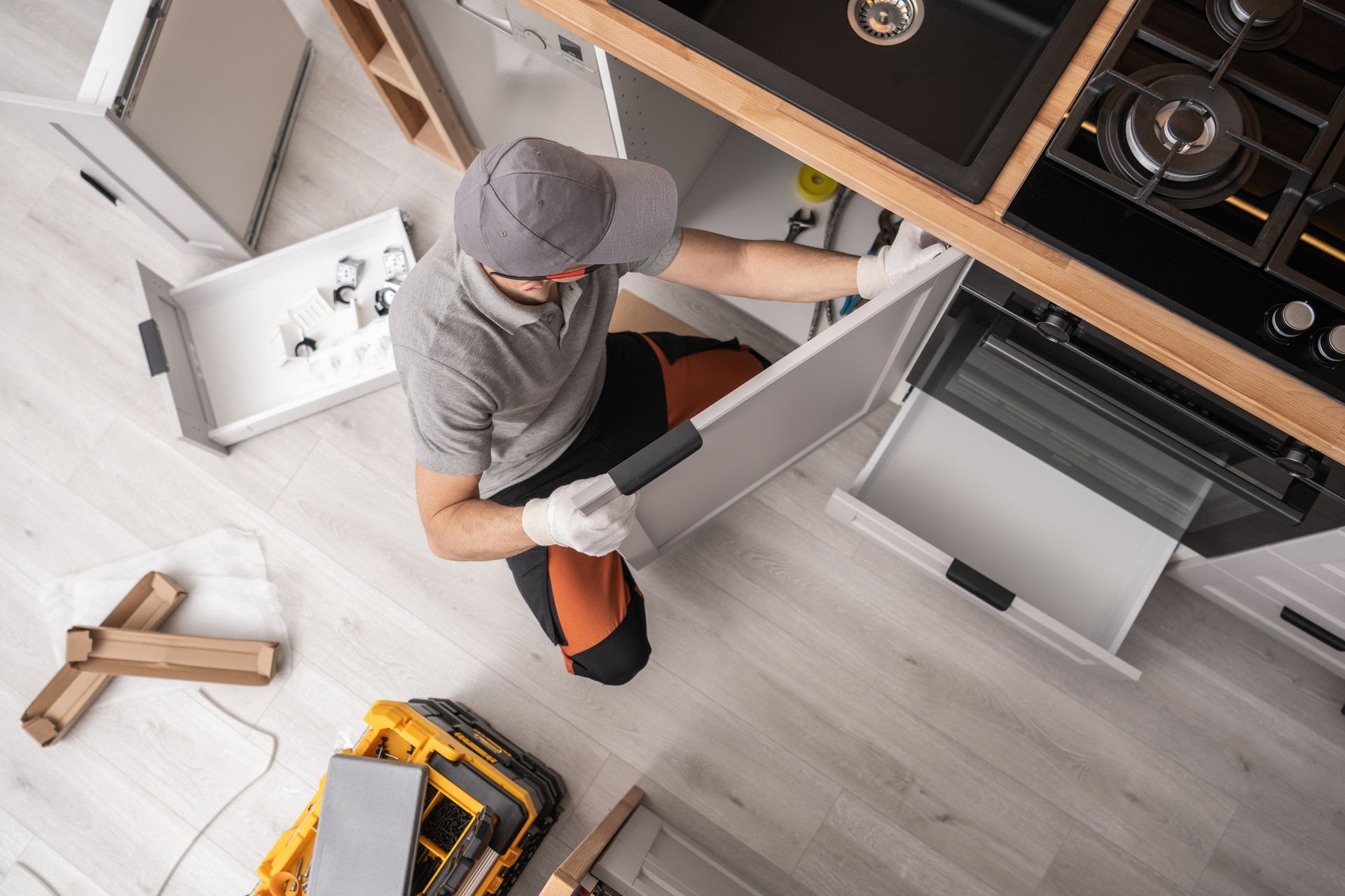 Kitchen cabinetmaker installing furniture inside a apartment.