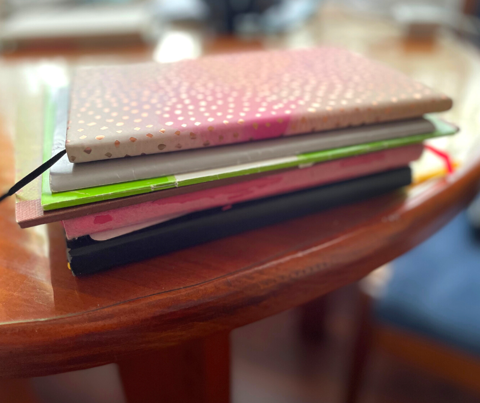 A stack of journals and notebooks