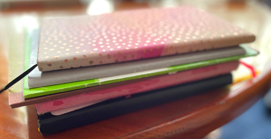 A stack of journals and notebooks