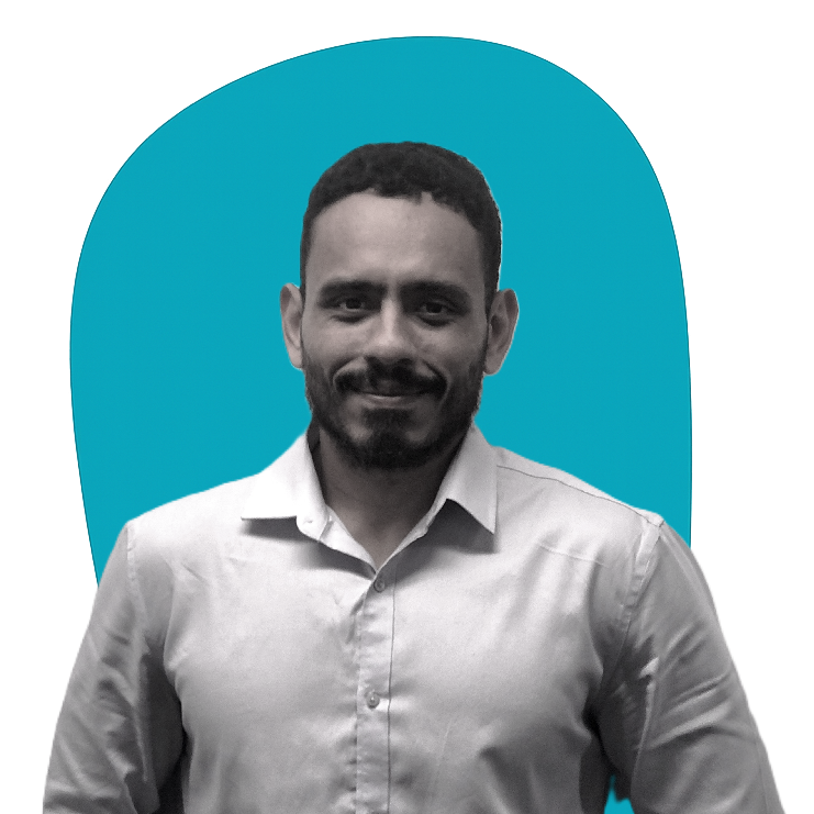 Man in a white shirt smiling against a teal background