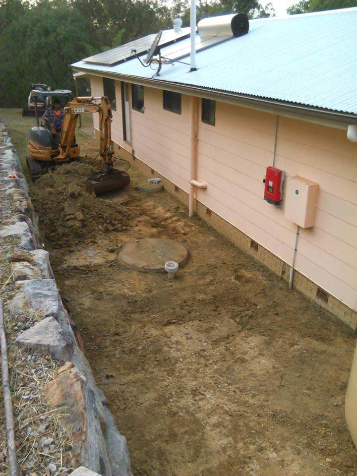 Excavator digging earth in backyard - Concrete footing and slabs Toowoomba, QLD