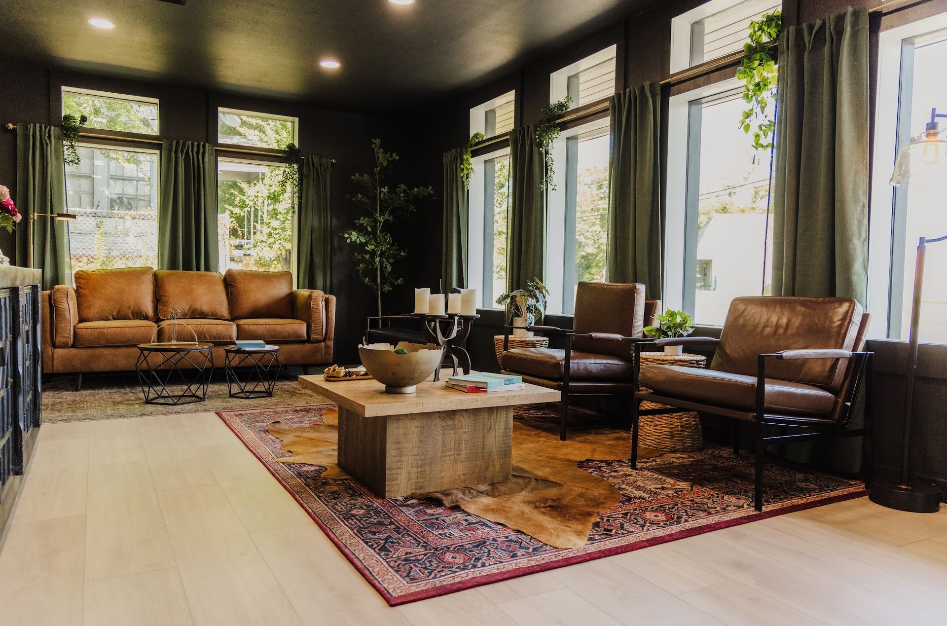 A living room with a couch , chairs , coffee table and rug.