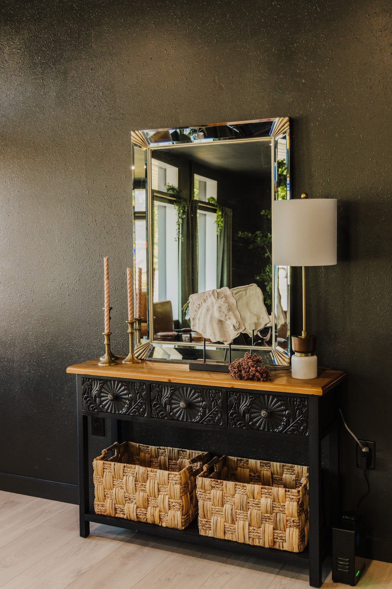 There is a mirror on the wall above the table.