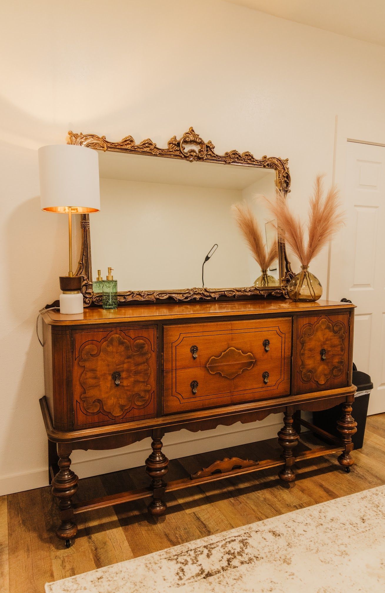 A wooden dresser with a mirror on top of it in a living room.