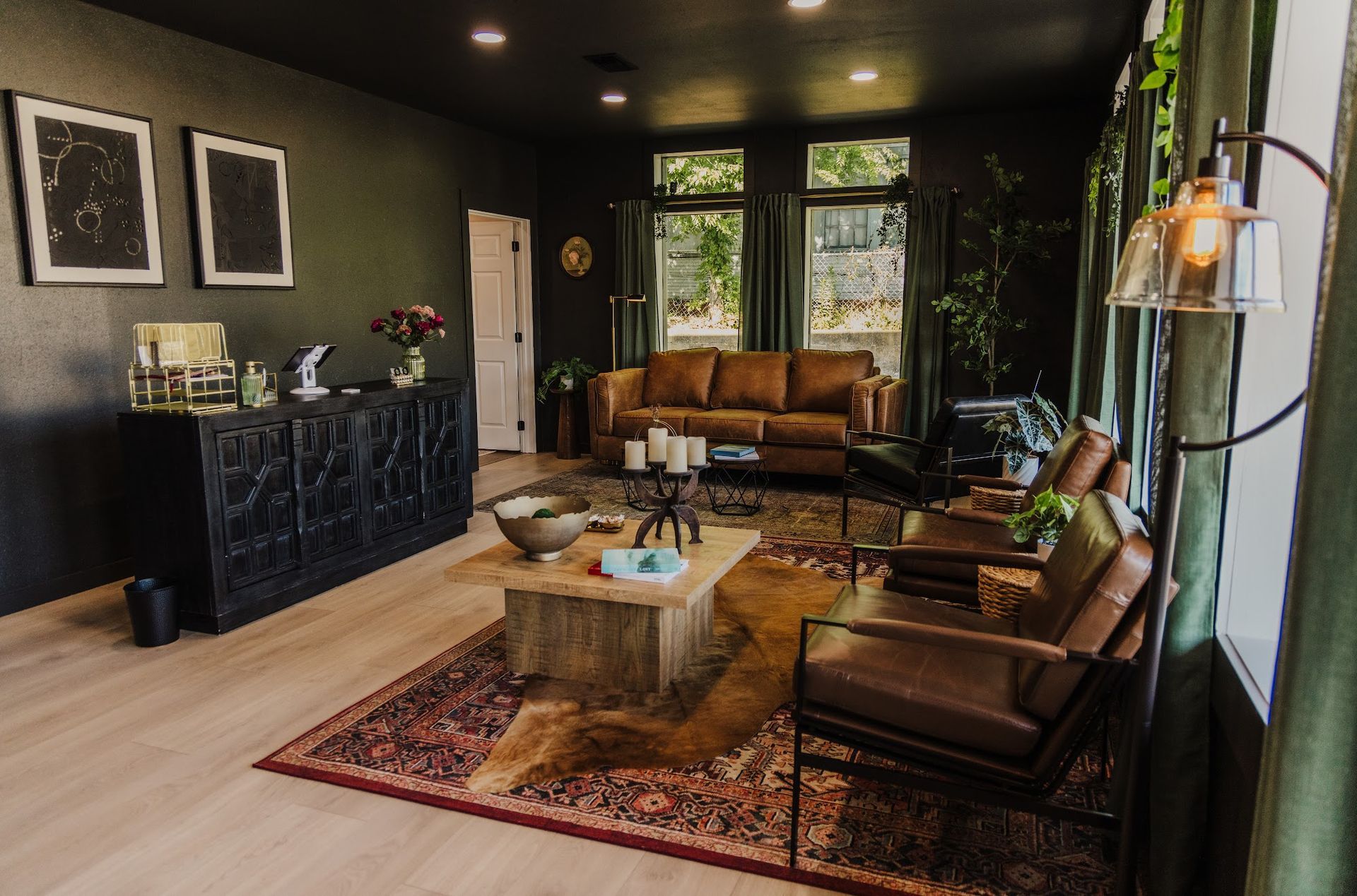 A living room with a couch , chairs , coffee table and rug.