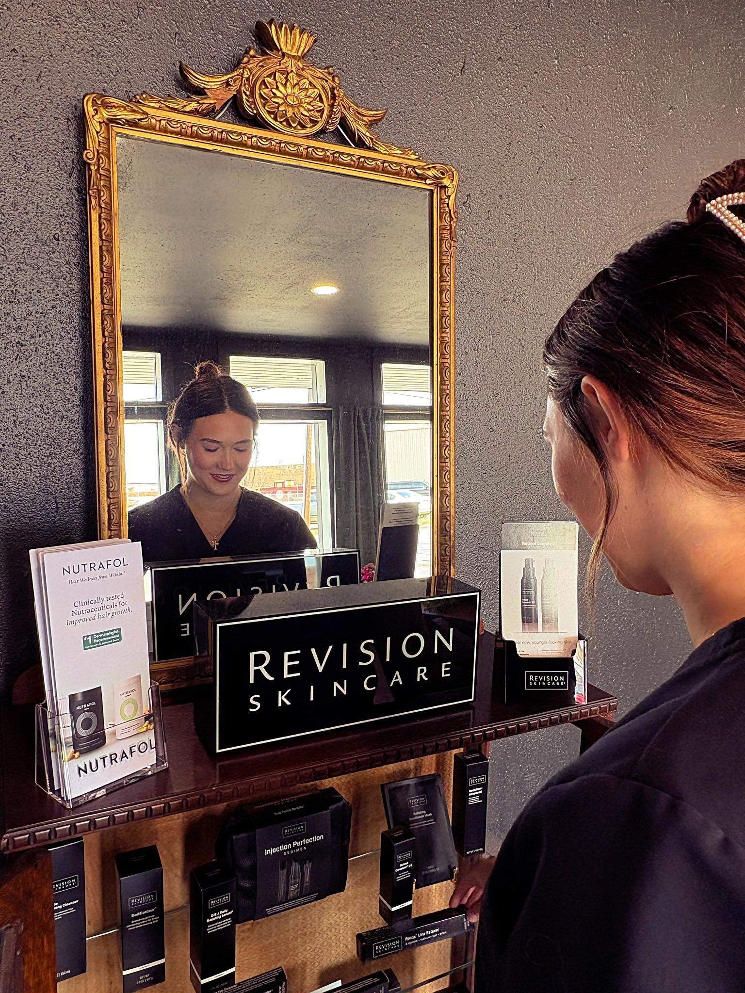 A woman is looking at her reflection in a mirror.