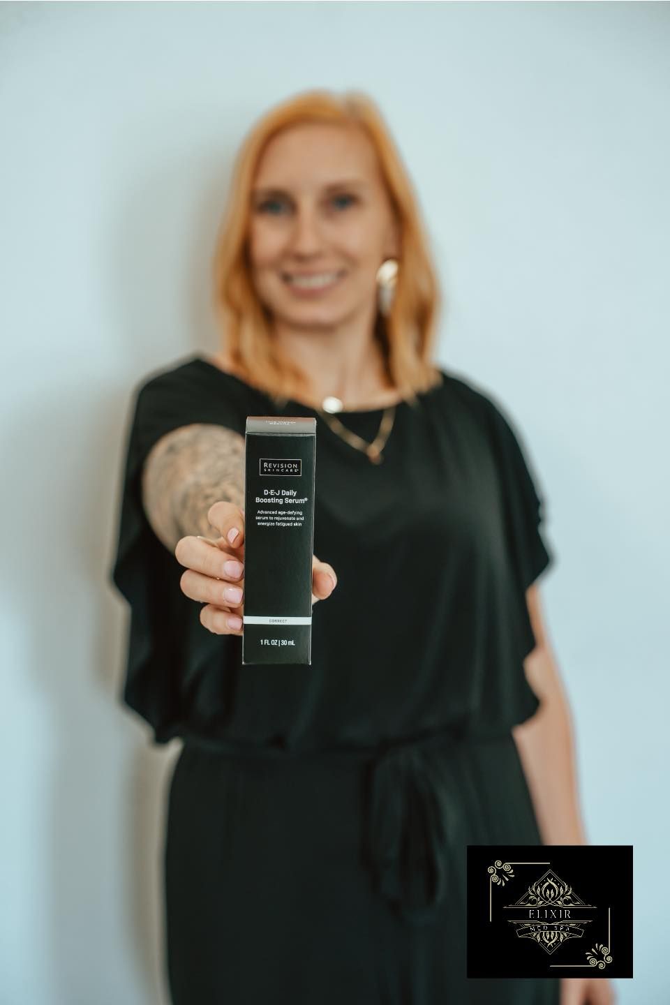 A woman in a black dress is holding a remote control in her hand.