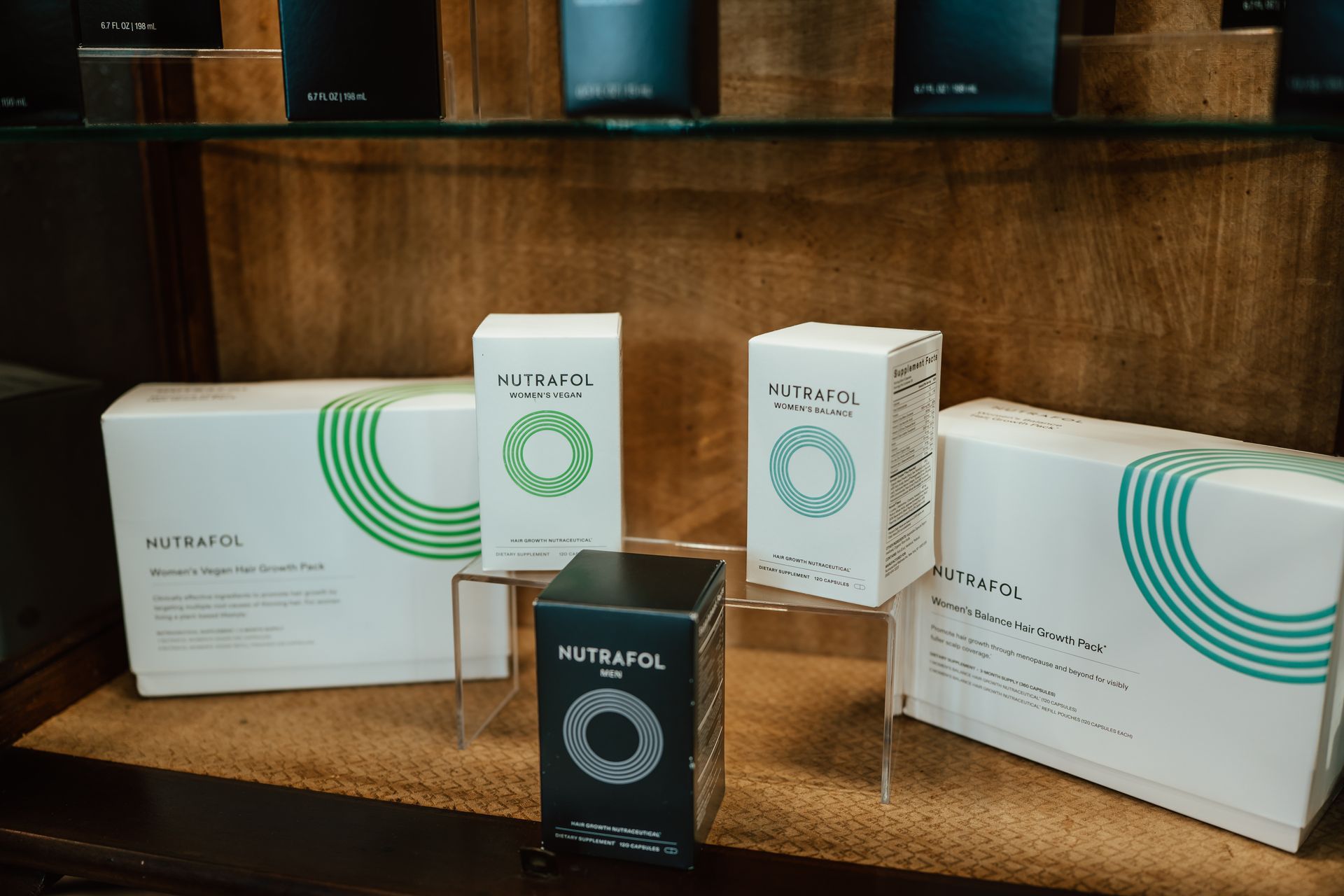 Shelves with boxes of Nutrafol supplements; green and white packaging.