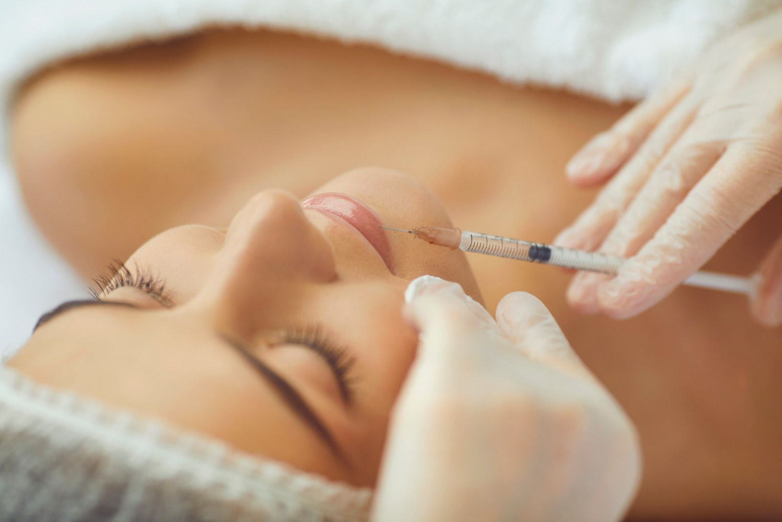 A woman is getting a botox injection in her face.