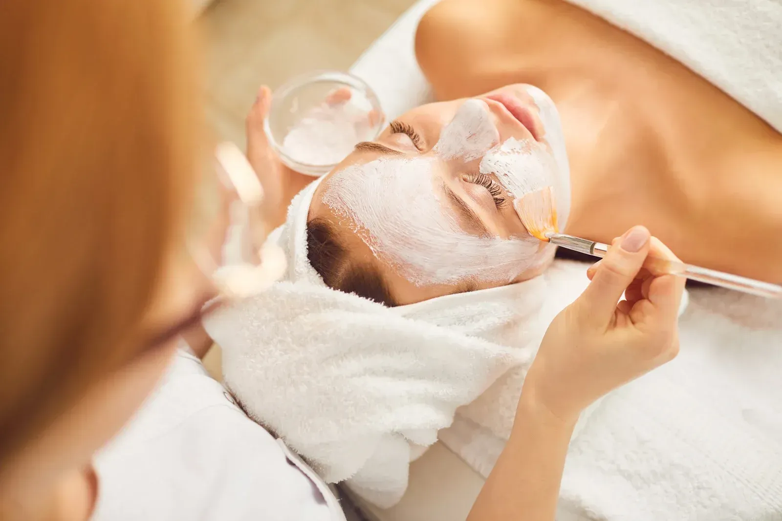 A woman is getting a facial treatment at a spa.