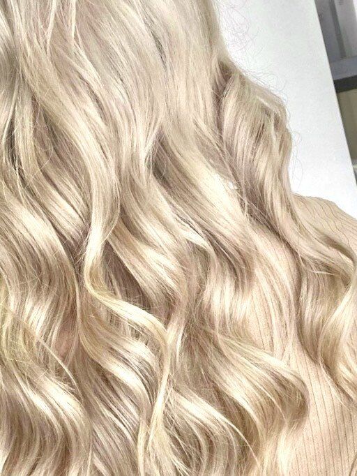 A close up of a woman 's blonde wavy hair - Hairdresser in Mackay, QLD