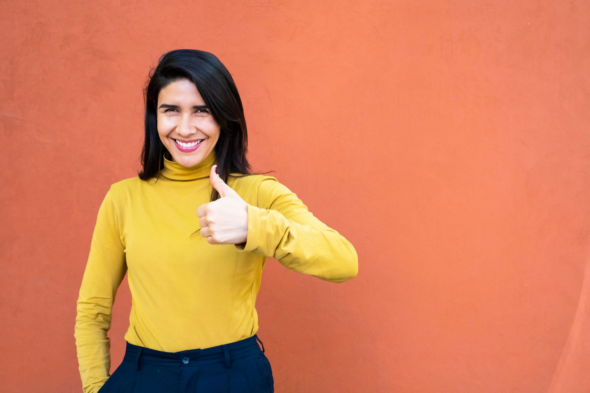 a lady in a yellow shirt with her thumbs up