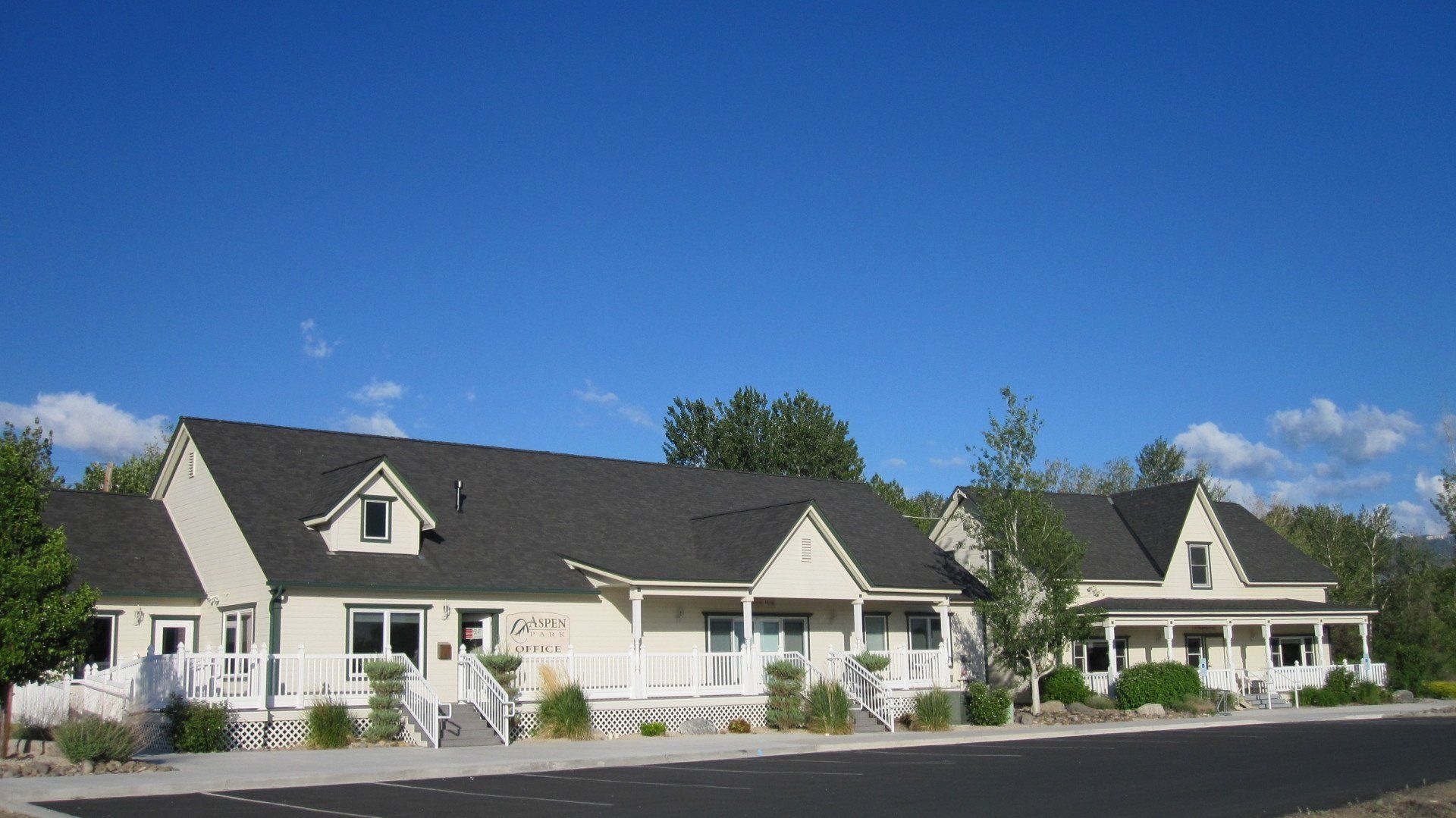 A row of white houses with black roofs and porches