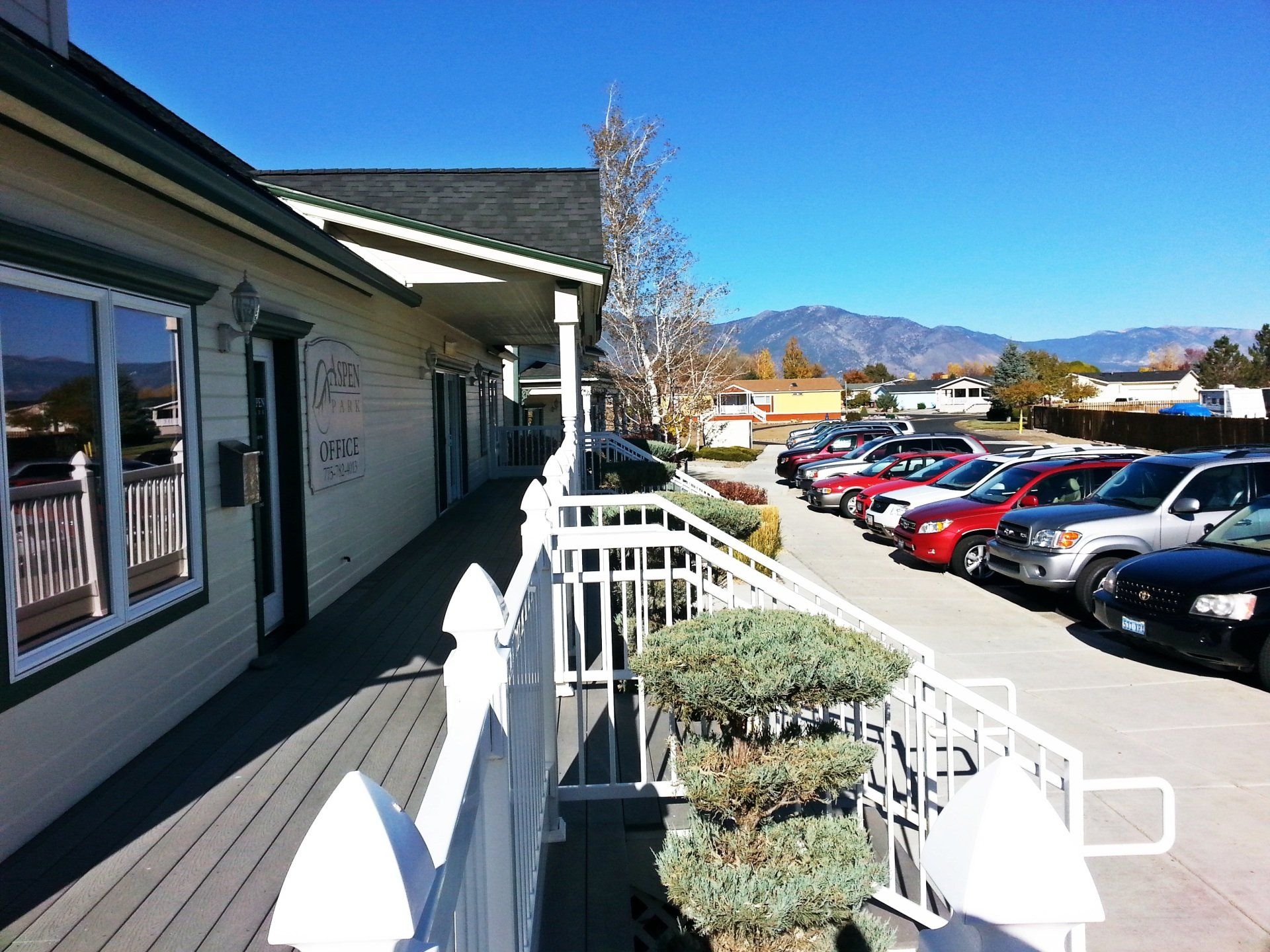 A row of cars are parked in front of a building