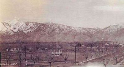 A black and white photo of a field with mountains in the background.
