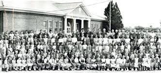 A large group of people are posing for a picture in front of a building.