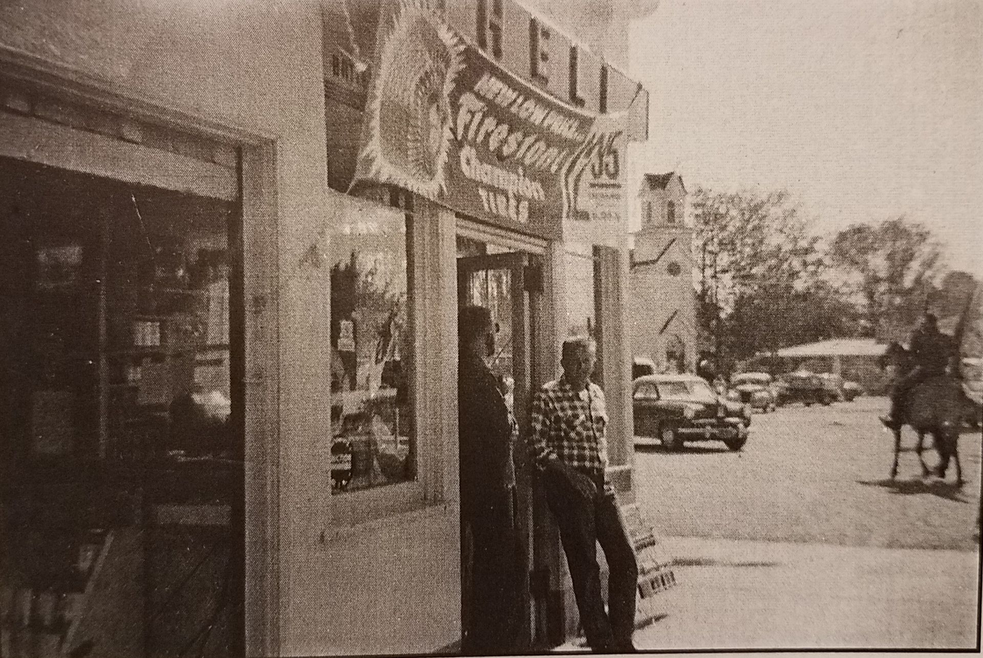 A black and white photo of people standing outside a store called helix