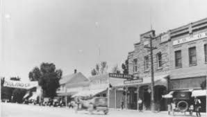 A black and white photo of a row of buildings in a small town.