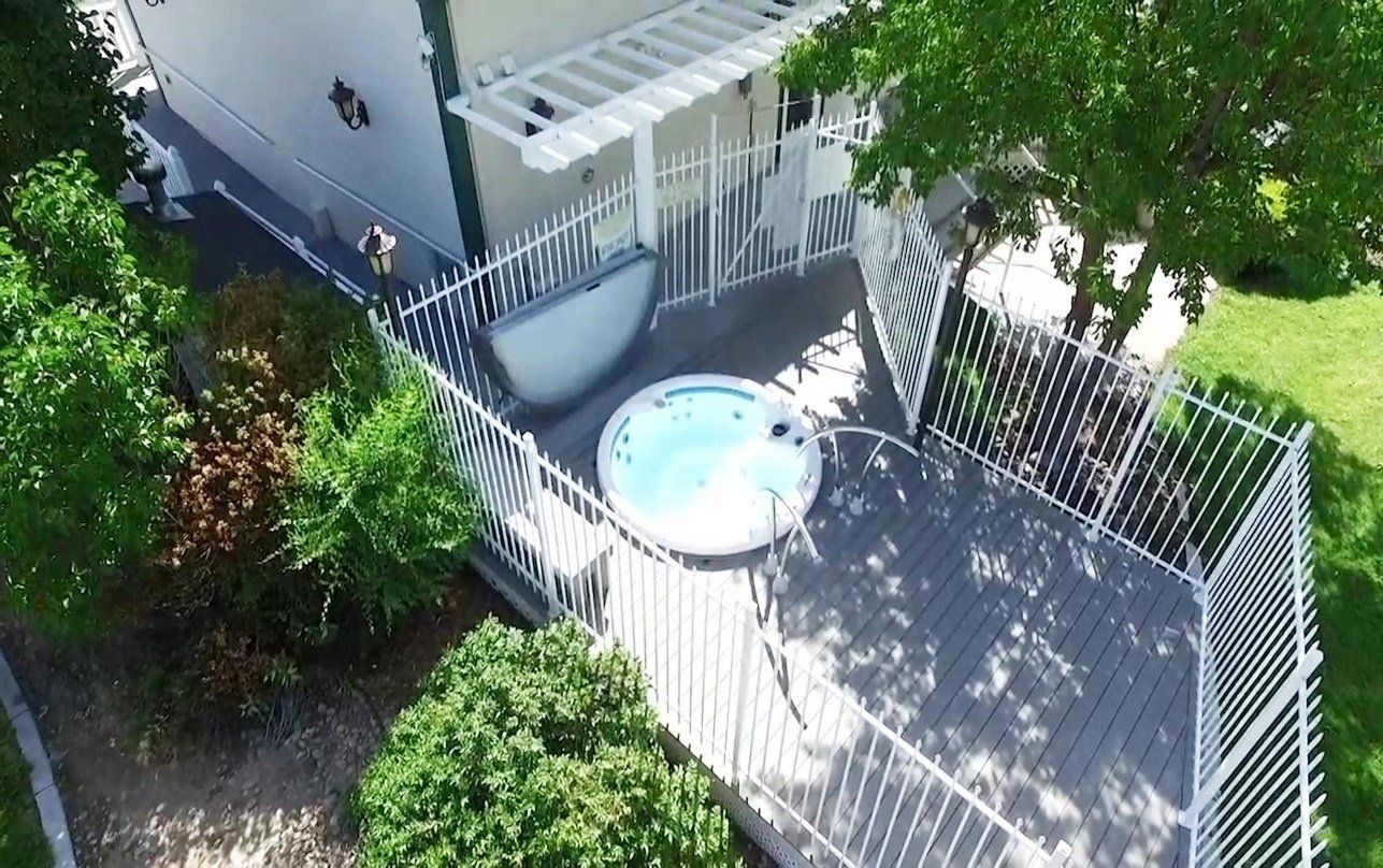 An aerial view of a house with a hot tub on the deck