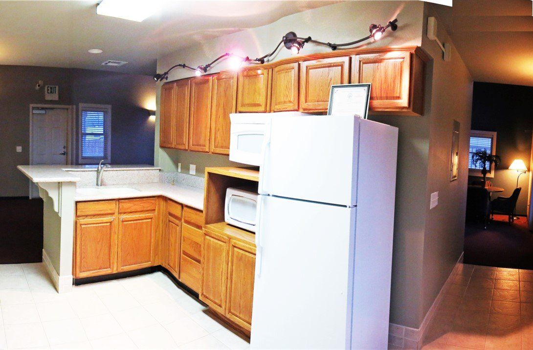 A kitchen with wooden cabinets and a white refrigerator