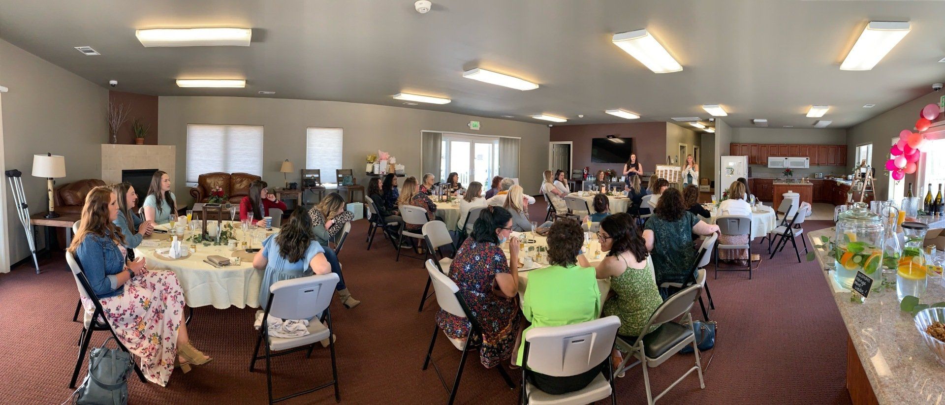 A large group of people are sitting at tables in a large room.