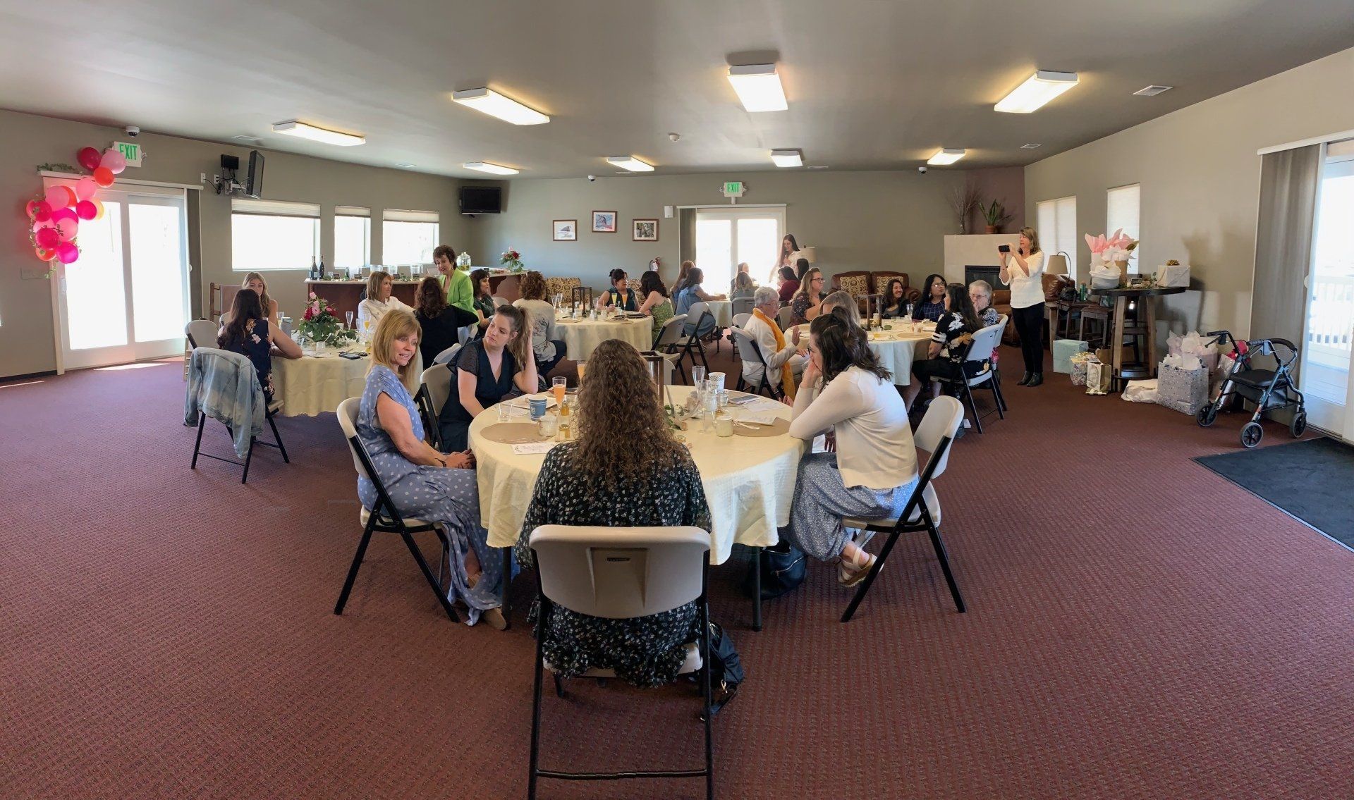 A group of people are sitting at tables in a large room.