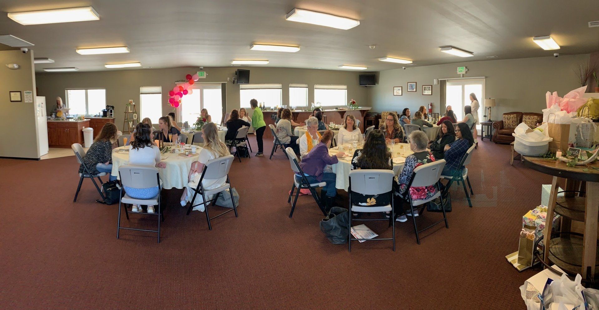 A group of people are sitting at tables in a large room.
