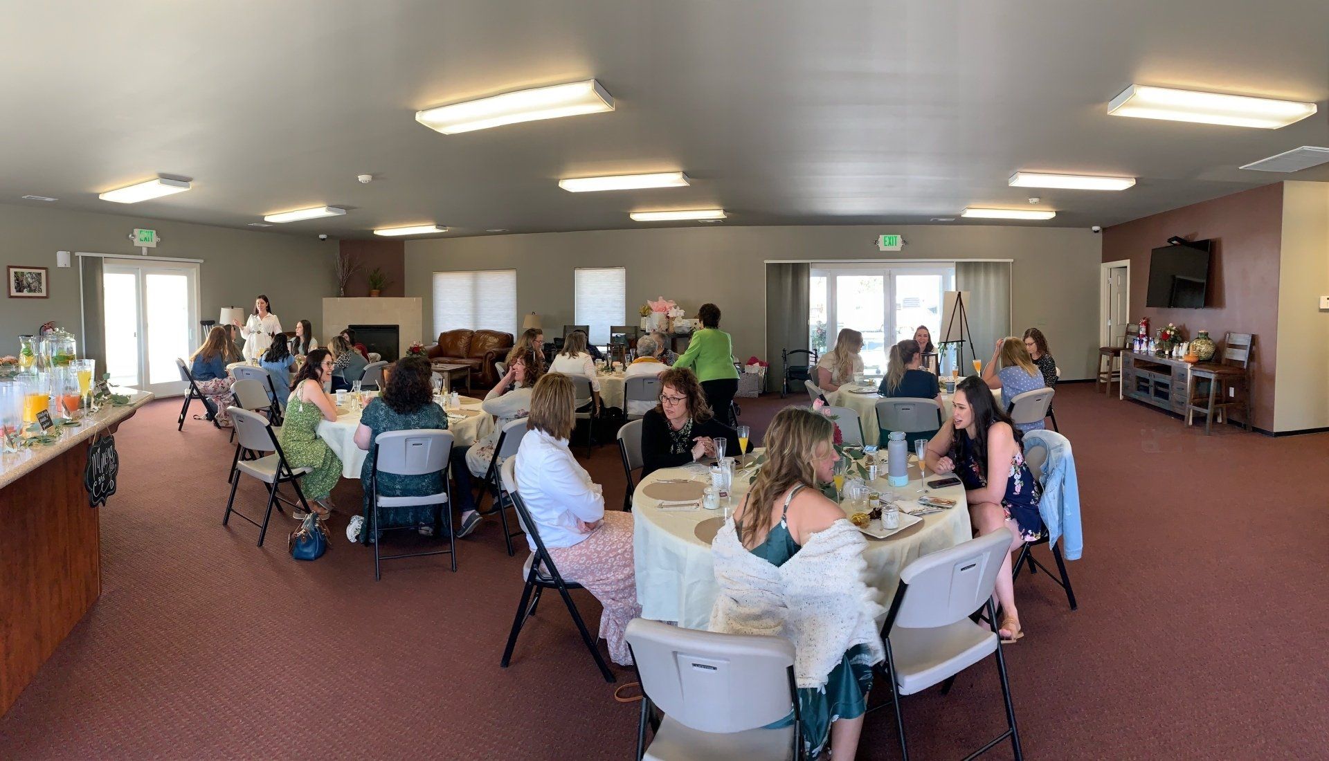 A group of people are sitting at tables in a large room.