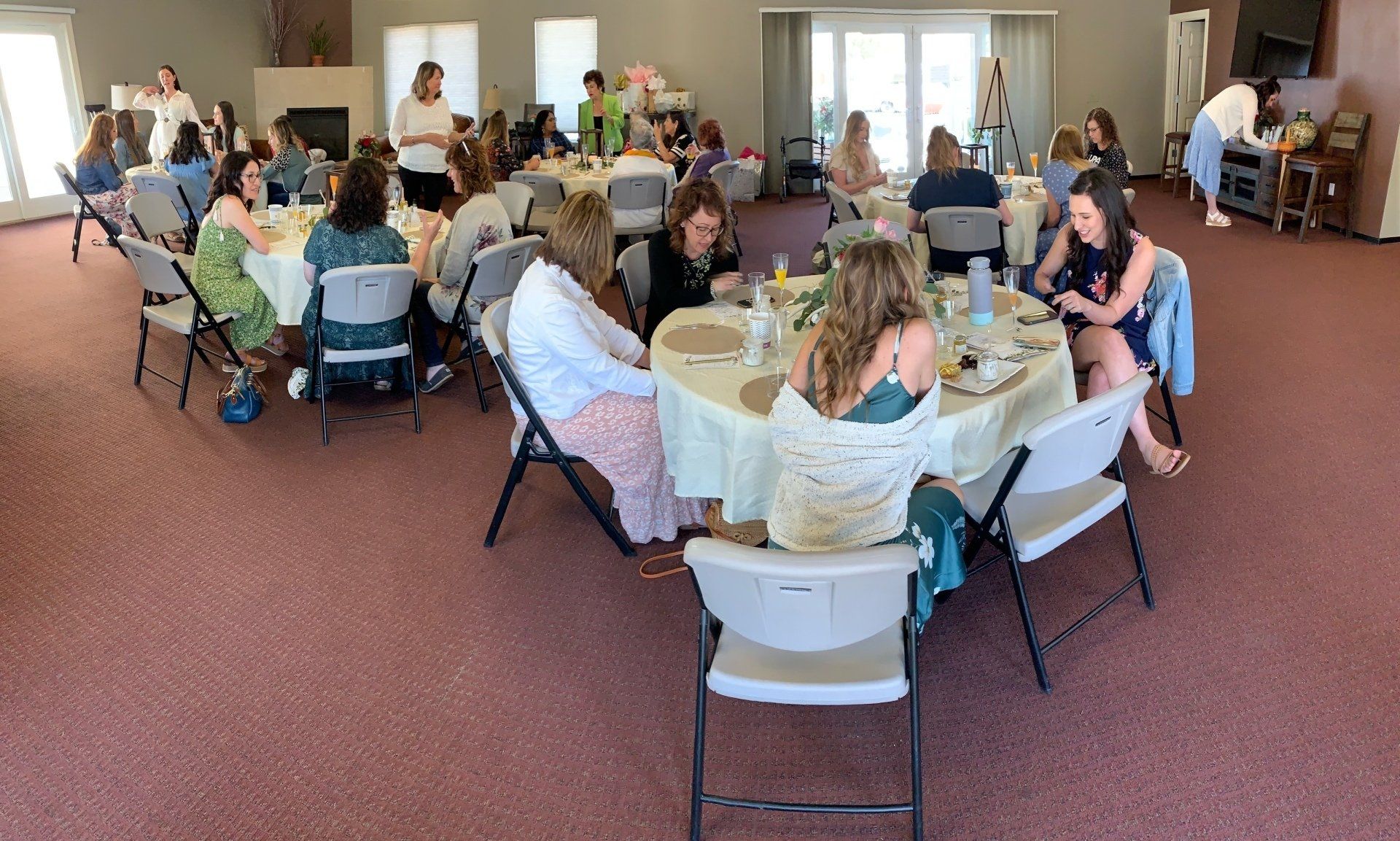 A large group of people are sitting at tables in a room.