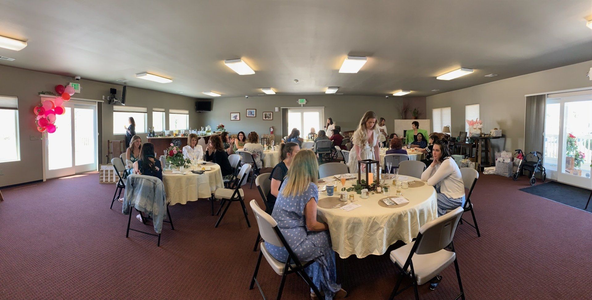 A group of people are sitting at tables in a large room.