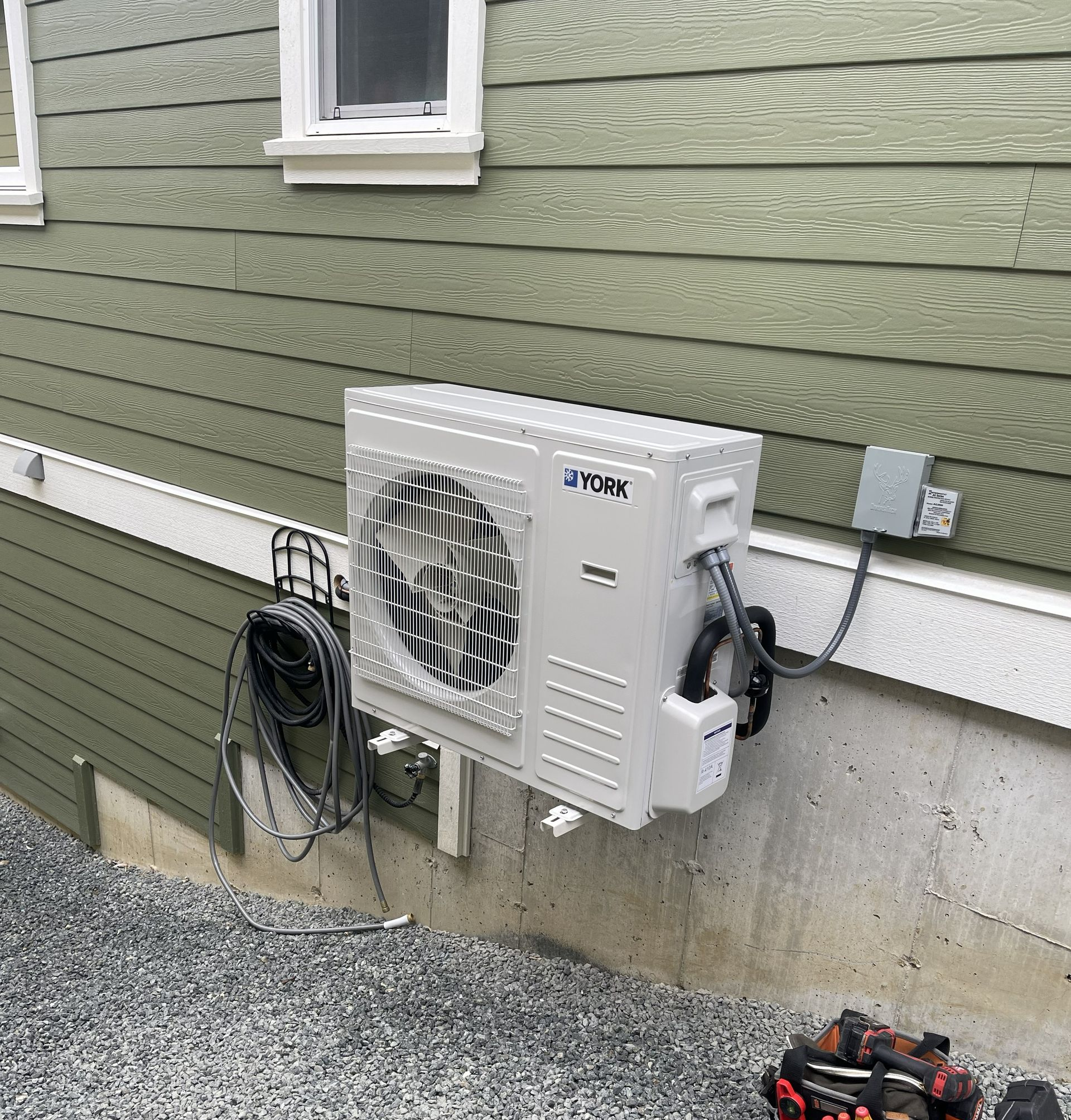 Side-by-side comparison of an outdoor AC condenser and an indoor furnace and water heater installation.