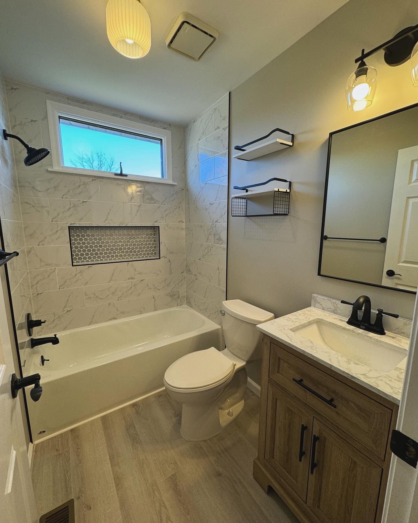 A bathroom with a toilet , sink , bathtub and shower.