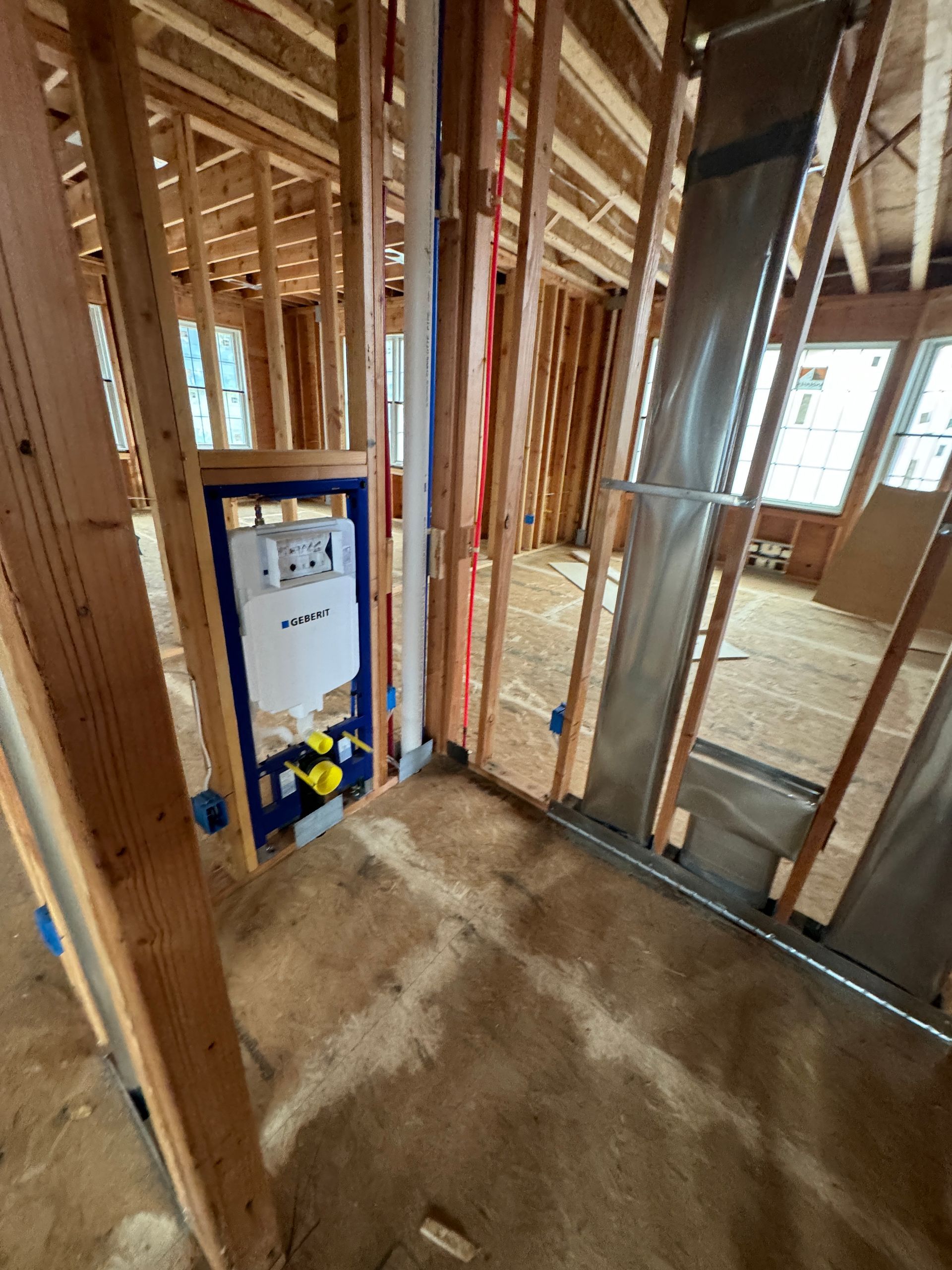 A bathroom in a house under construction with a toilet.