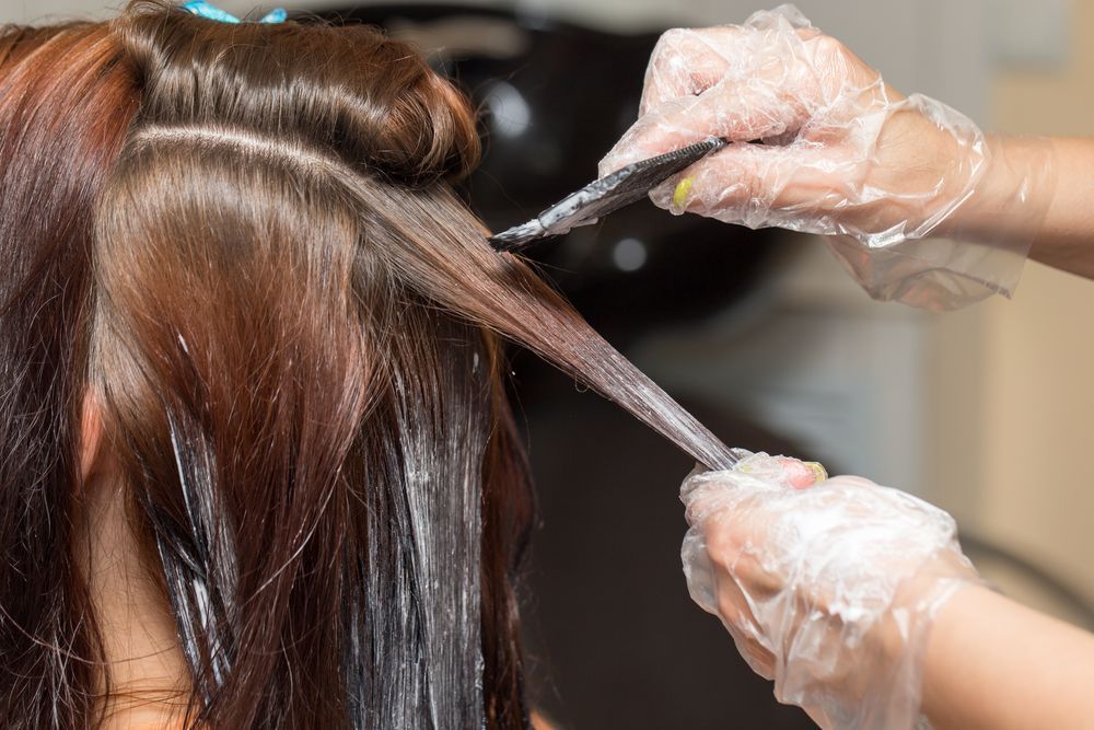 Hands in Gloves Applying Hair Dye to Brown Hair — Amore 'D' Hair Studio in Mudjimba, QLD
