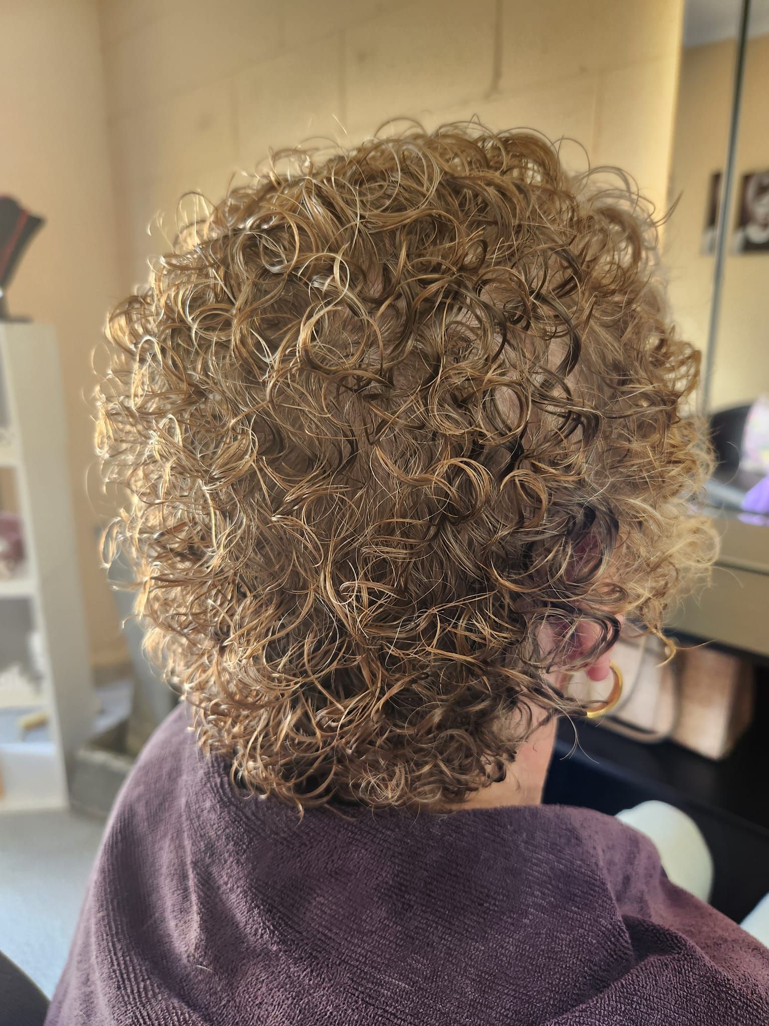 Person with short, tightly curled, light brown hair; sitting indoors. — Amore 'D' Hair Studio in Mudjimba, QLD