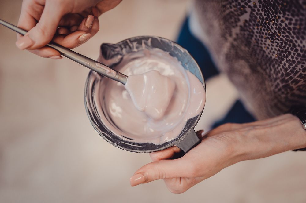 Hands Mixing Hair Dye in a Bowl With a Metal Tool — Amore 'D' Hair Studio in Mudjimba, QLD