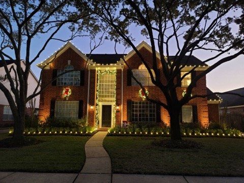 A large brick house with christmas lights on it