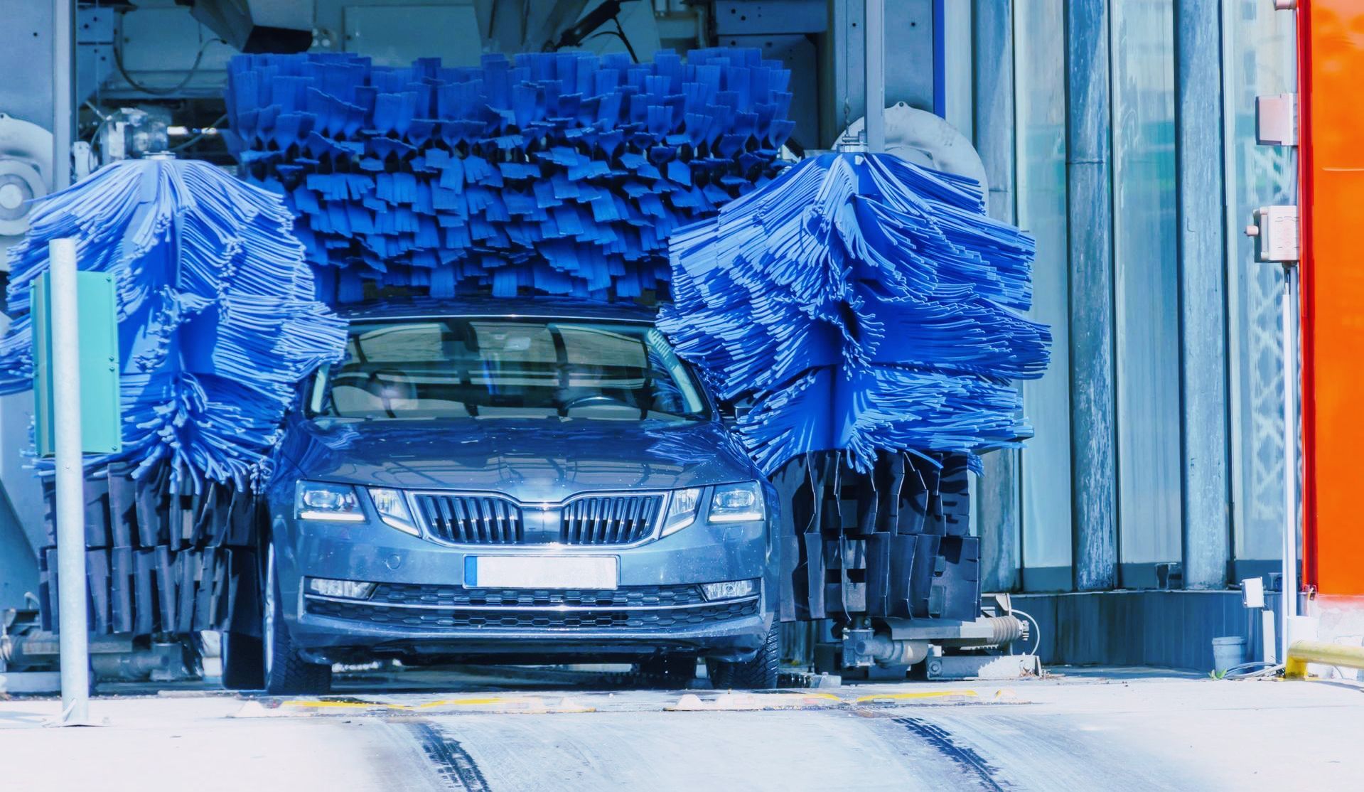 A man is sitting in a car looking at his phone.