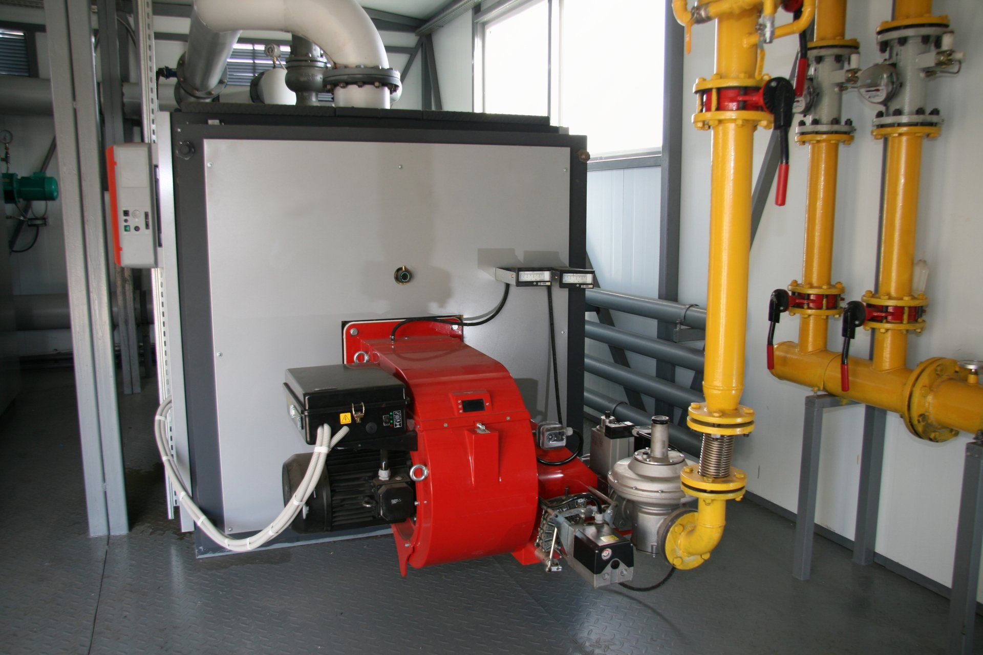 A room with yellow pipes and a red machine
