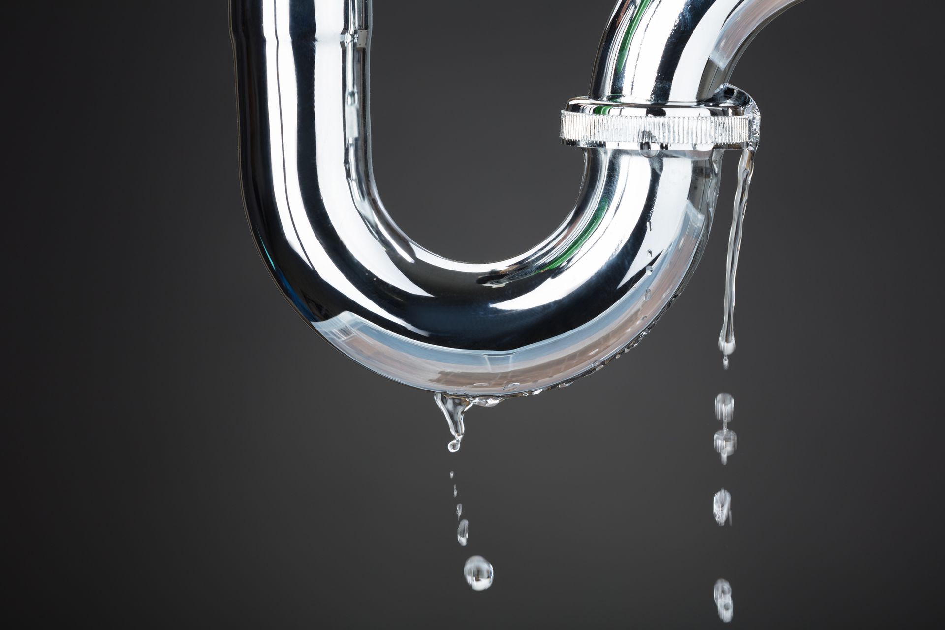 A close up of a drain pipe with water leaking out of it.