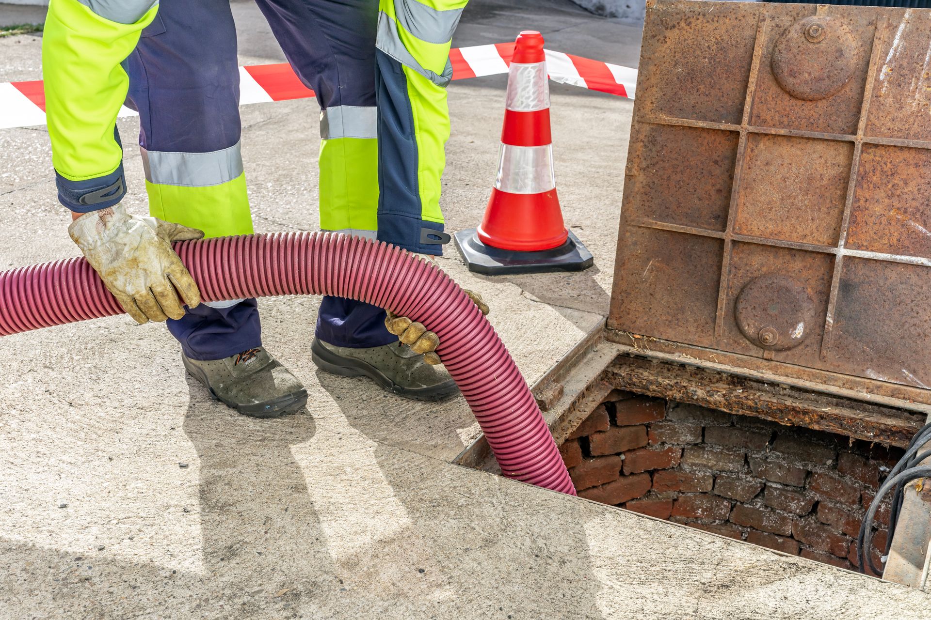 Sewer worker with PPE cleaning.