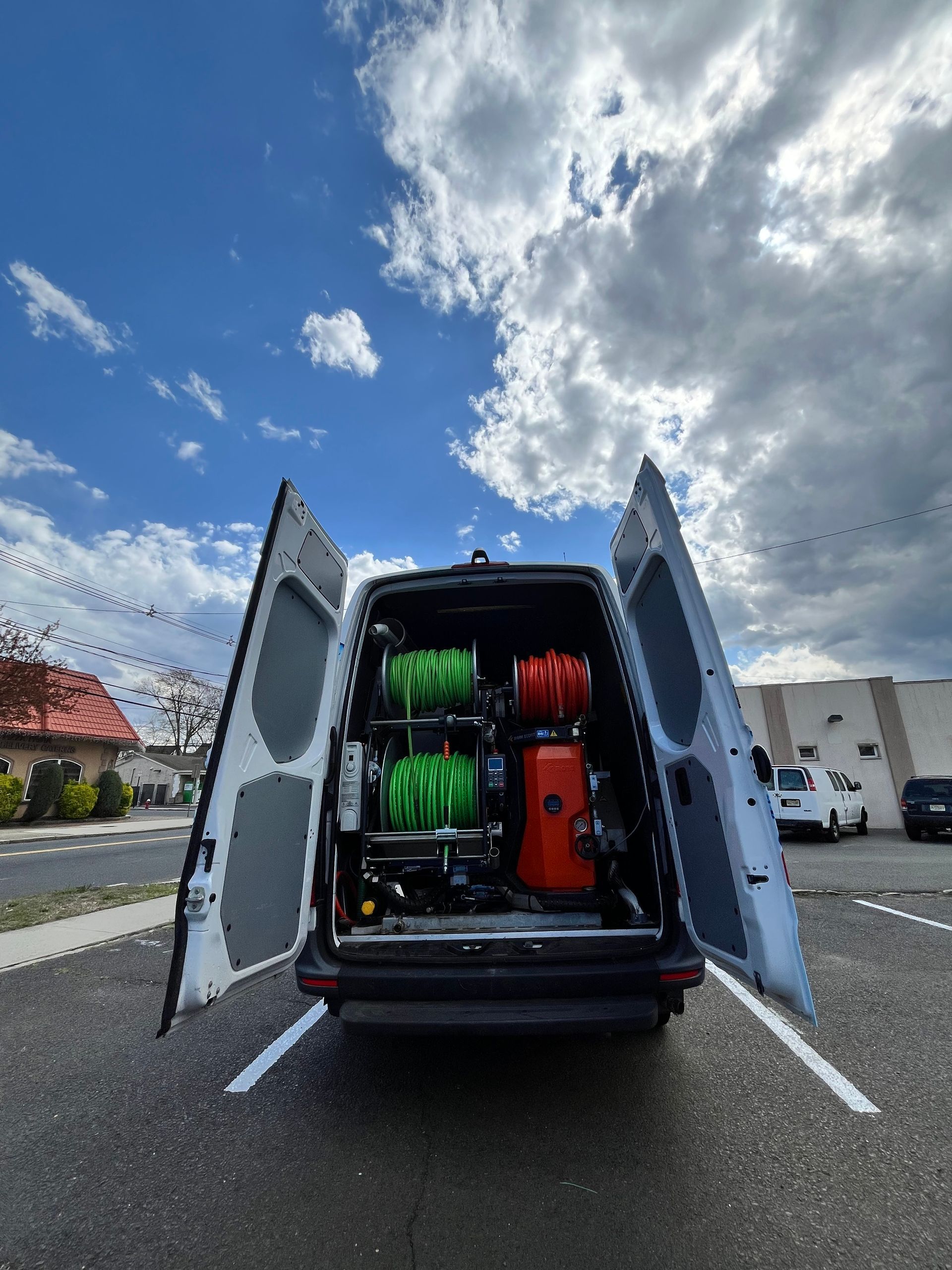 A van is parked in a parking lot with its doors open