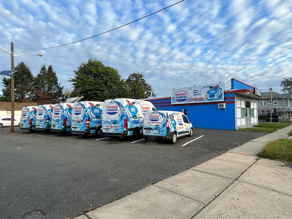 A row of vans are parked in front of a blue building