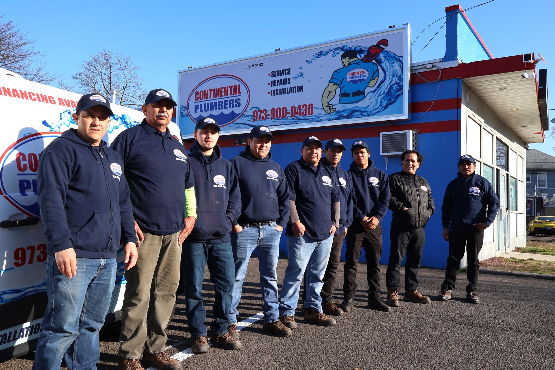 A group of men are posing for a picture in front of a building.