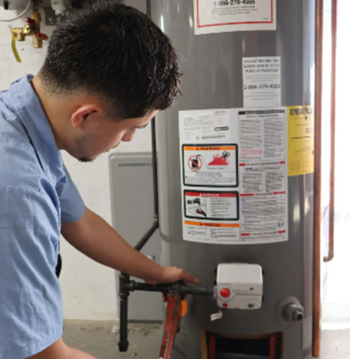 Technician repairing an open water heater unit.