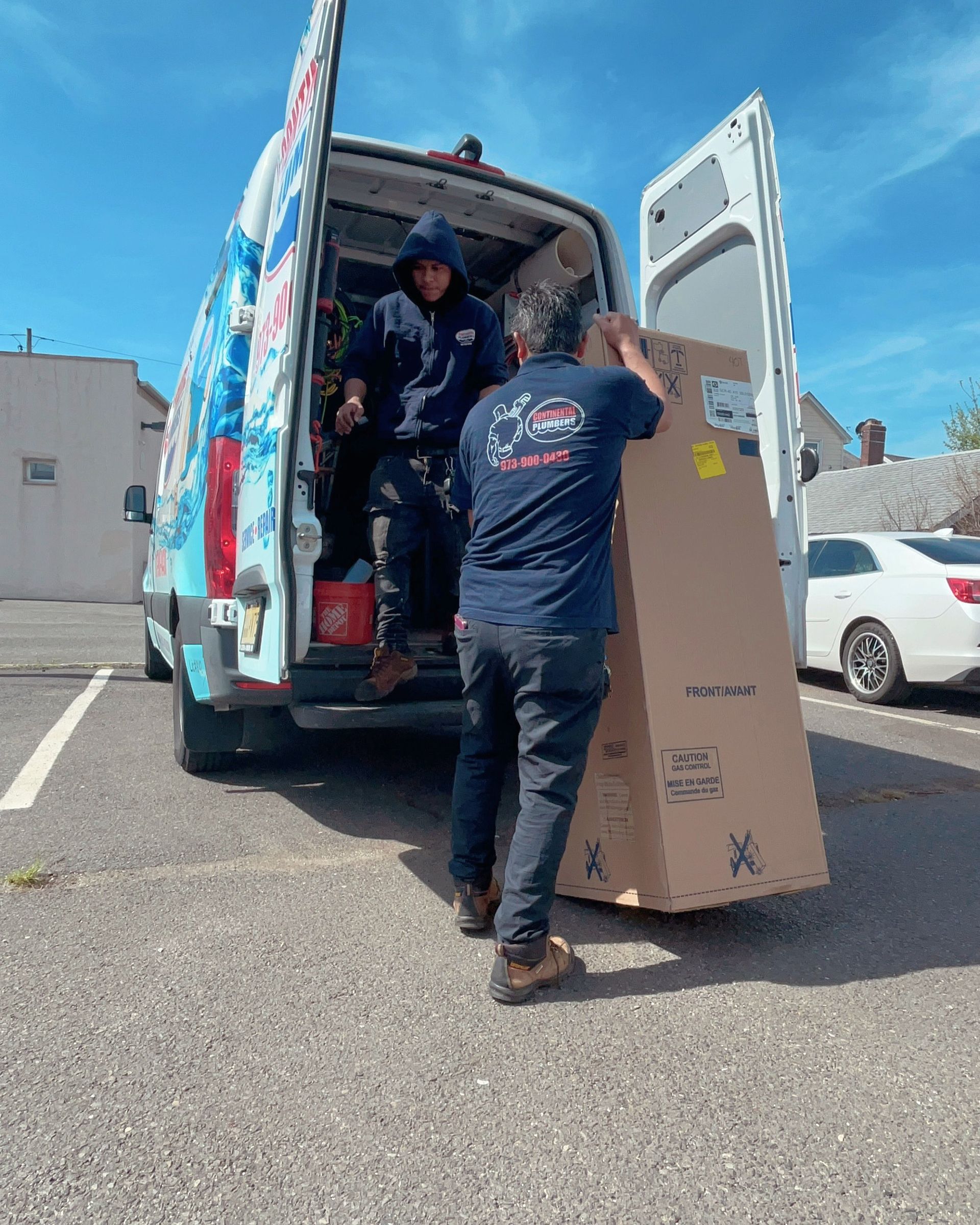 Two men are loading a box into a van.