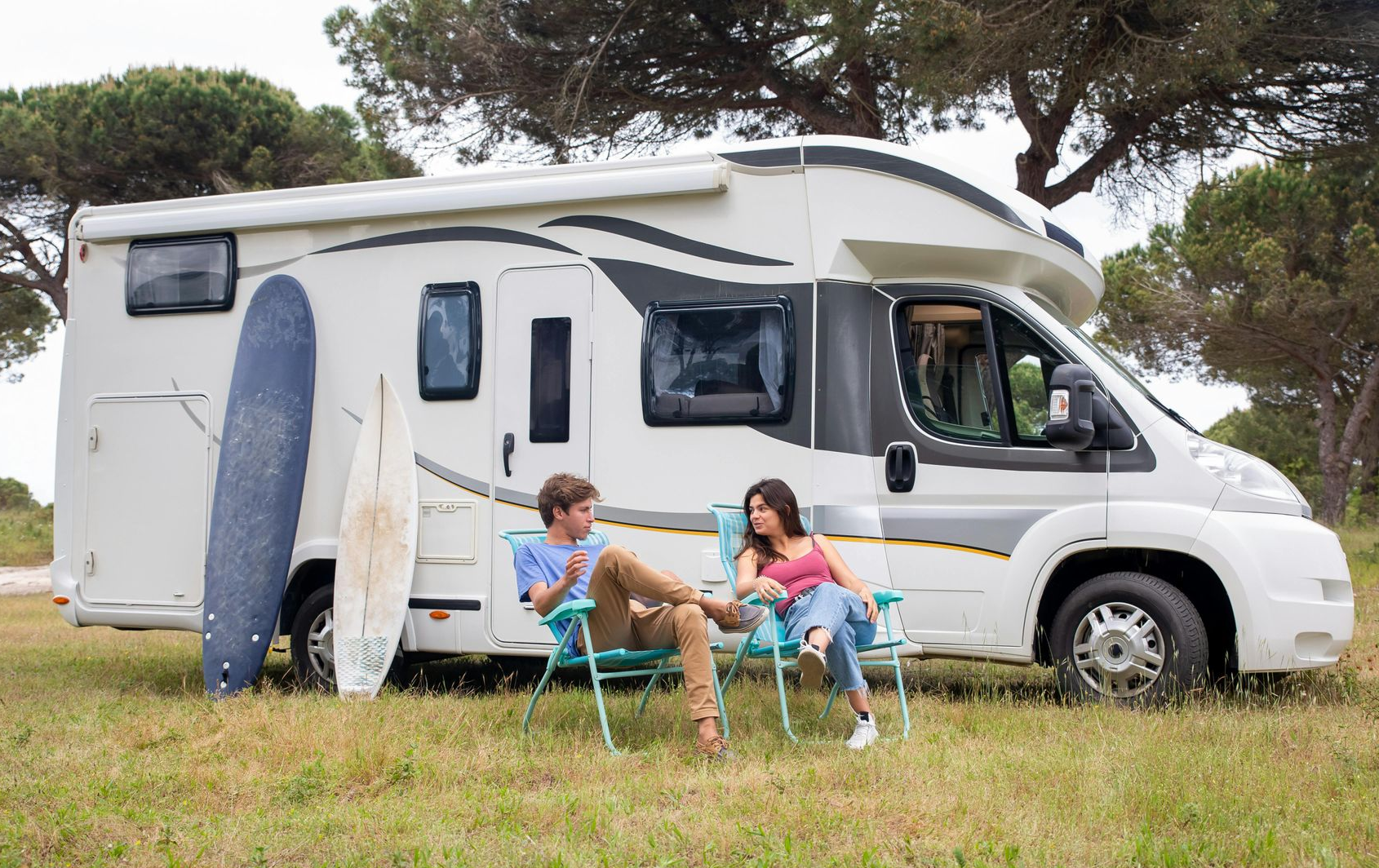 People on chairs outside with a RV in the background