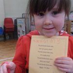 little girl holding a poem