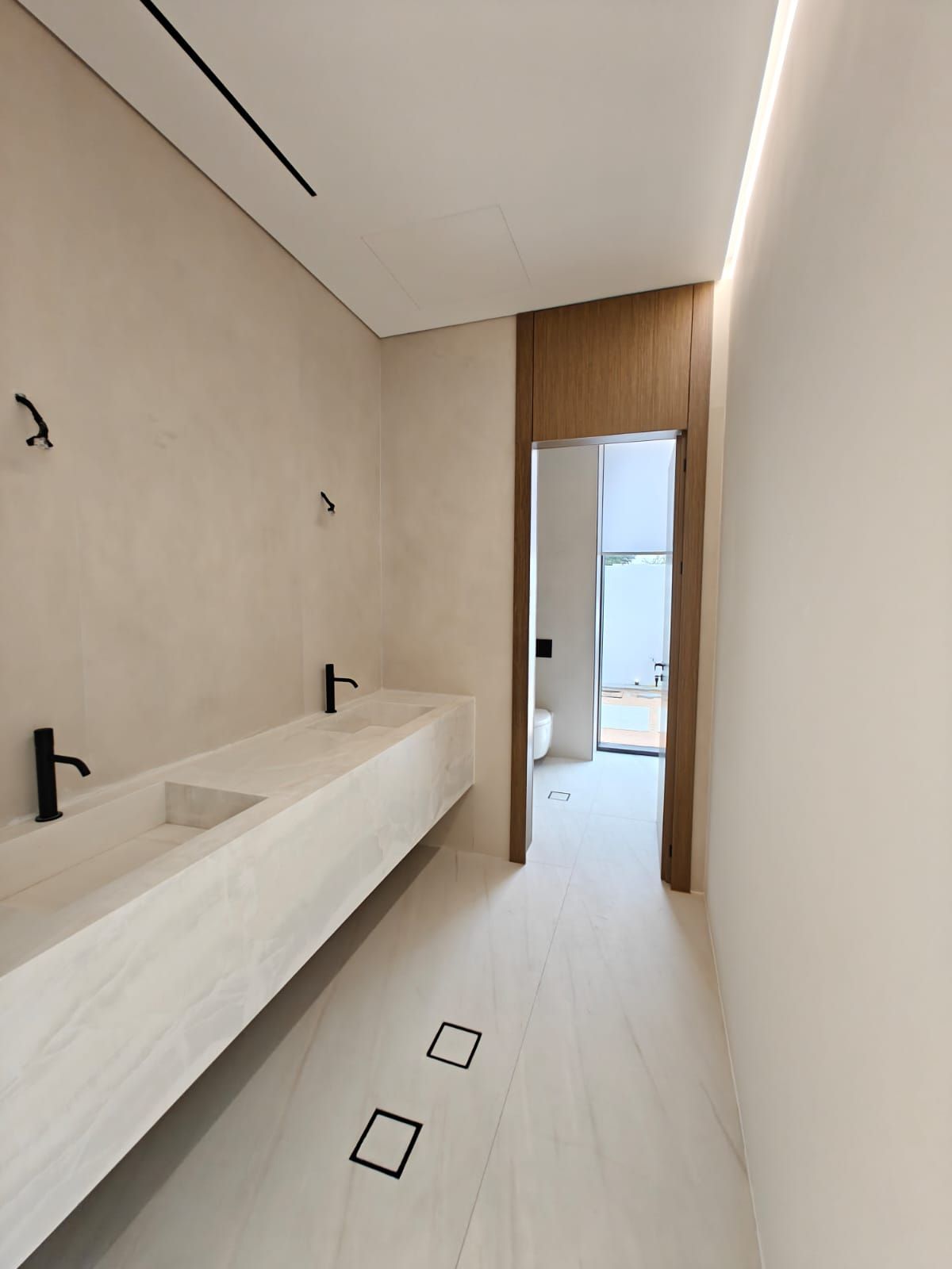 Luxury guest bathroom in Dubai with travertine finishes and premium detailing by Concept Art Decor.