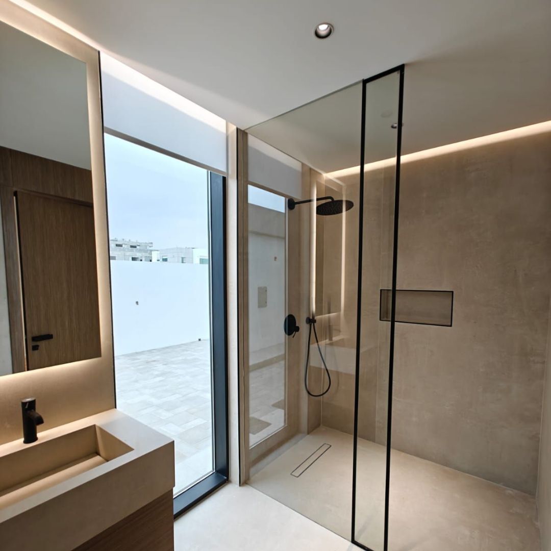 Modern bathroom with gold fixtures and marble tiles designed by Concept Art Decor.